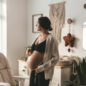 Pregnant lady standing in a nursery