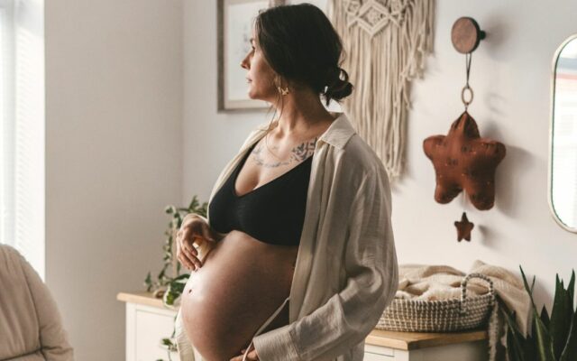 Pregnant lady standing in a nursery