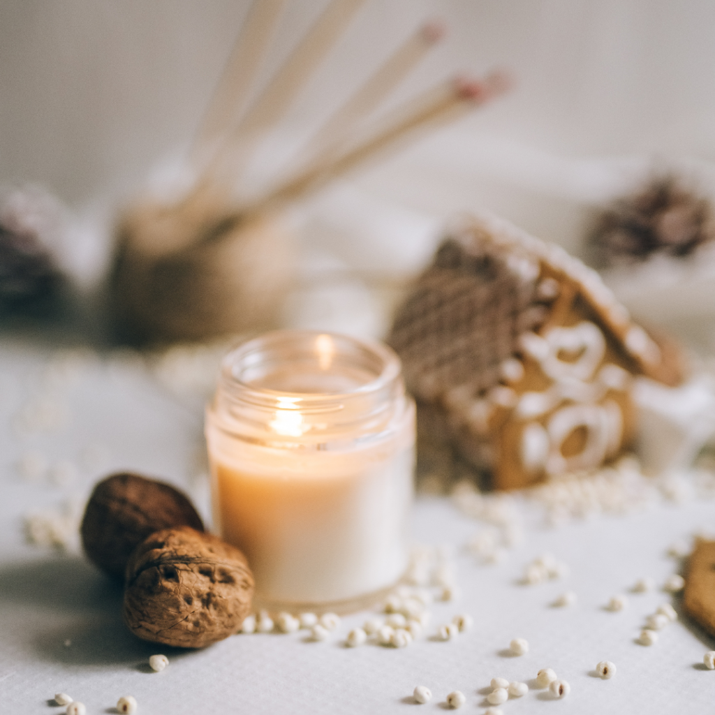 Candle with Ginger Bread House Behind.